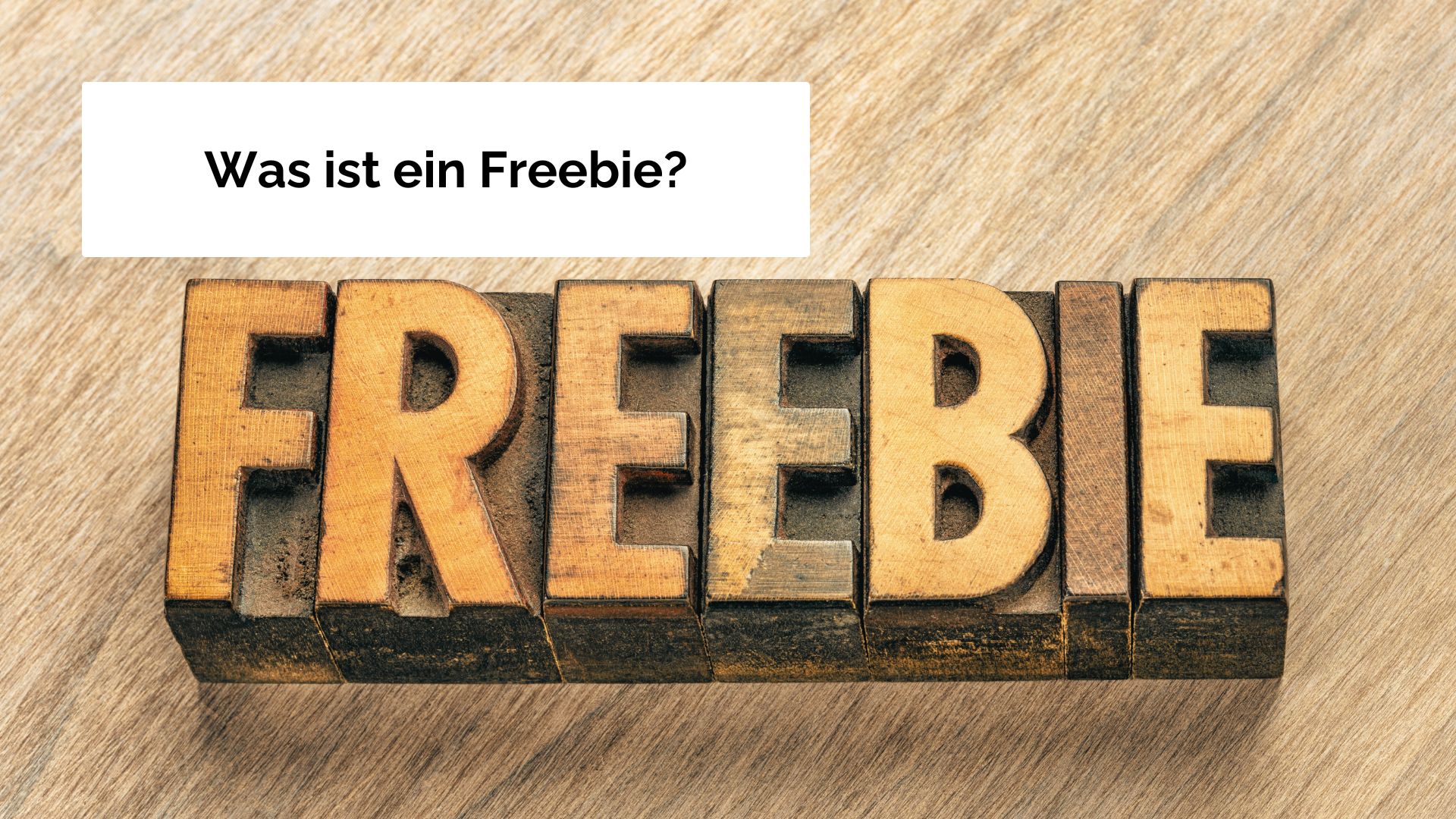 Mehrere Holzbuchstaben-Stempel die nebeneinander gelegt wurden und das Wort Freebie ergeben.