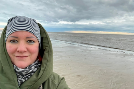 Stefanie mit Mütze und dickem Mantel im Winter am Strand an der Nordsee