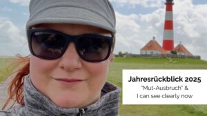 Beitragsbild zum Blogartikel "Jahresrückblick 2025" - zu sehen ist Stefanie mit Sonnenbrille, Cap und vom Wind zerzausten Haaren, die vor einem gestreiften Leuchtturm steht
